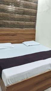a bed with two pillows on it in a room at Hotel Kanhaiya Inn in Haridwār