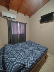 a bedroom with a bed and a television in a room at Departamentos RIMASHA in Federación