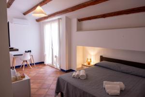 a bedroom with a bed with two towels on it at Al Palmento Country Hotel in Syracuse +41 photos