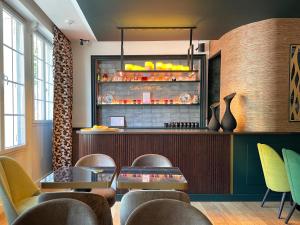 a restaurant with a bar with tables and chairs at ELSA, Hôtel Paris by Collection Vesper in Paris
