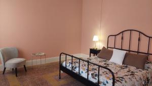 a bedroom with a bed and a chair and a lamp at Sa Bonora in Iglesias