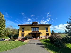 a large yellow house with a pathway in front at El Balcón Del Profesor in Cereceda +13 photos