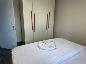 a bed with a white blanket on top of it at carmel cabins suite nu 8 in Haifa