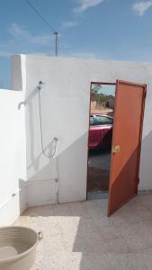 a door leading into a parking lot with a car at Najib in Djerba +48 photos