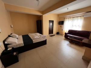a hotel room with a bed and a couch at Hotel Cymbidium Residency in Tādong +28 photos