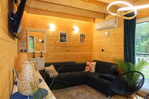 a living room with a couch and a table at Mazury Czerwony Domek Jacuzzi in Romany