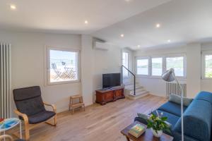 a living room with a blue couch and a tv at Casa Bortolo in Garda