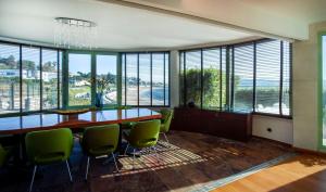 a dining room with a table and chairs and windows at Sea view Luxury Apartment in Paço de Arcos
