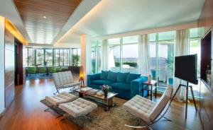 a living room with a blue couch and chairs at Sea view Luxury Apartment in Paço de Arcos