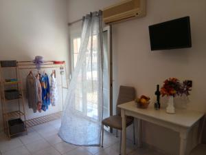 a room with a table and a window with a curtain at Sandra's Nest Gaios Paxos in Gaios