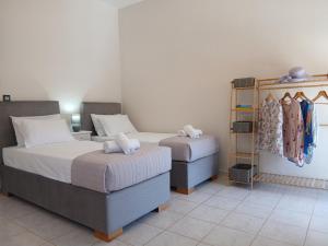 a bedroom with two beds and a shelf with clothes at Sandra's Nest Gaios Paxos in Gaios
