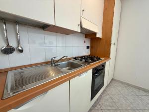 a kitchen with a sink and a stove at Ulivo Liguria With pool in Gazzelli