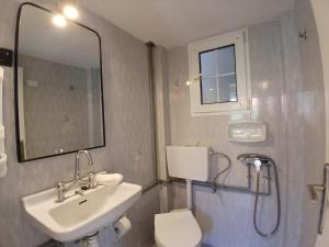 a bathroom with a sink and a toilet and a mirror at Sandra's Nest Gaios Paxos in Gaios +7 photos