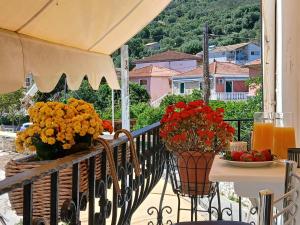 a balcony with a table with flowers on it at Sandra's Nest Gaios Paxos in Gaios