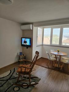 a living room with a table and a tv at Apartment ADI in Sarajevo