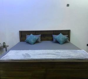 a bed with blue pillows on top of it at ZEN House Arugambay in Arugam Bay