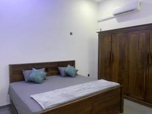 a bedroom with a wooden bed with blue pillows at ZEN House Arugambay in Arugam Bay