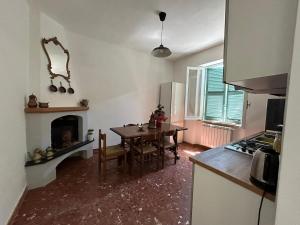 a kitchen and dining room with a table and a fireplace at laperladelfarfa in Castelnuovo di Farfa +15 photos
