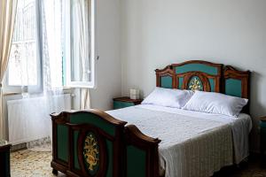 a bedroom with a bed with a wooden headboard and a window at laperladelfarfa in Castelnuovo di Farfa