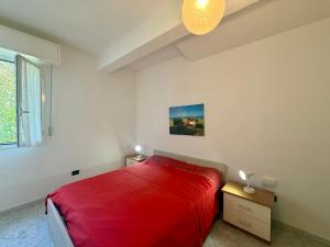 a white bedroom with a red bed and a window at Ulivo Liguria With pool in Gazzelli +19 photos