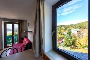 a room with a window with purple chairs and a view at Residenza Lorica in Lorica