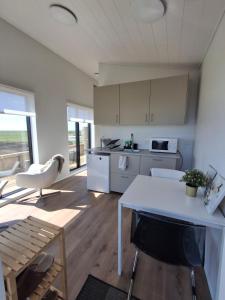 a kitchen with white cabinets and a table in a room at Hólmahjáleiga Guesthouse in Hvolsvöllur