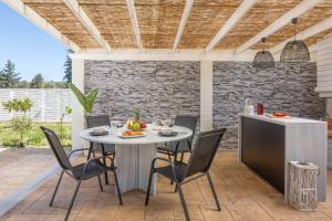 a patio with a table and chairs on a patio at Villa Elegio in Kavos