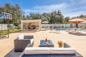 a patio with couches and a basketball hoop at Villa Elegio in Kavos