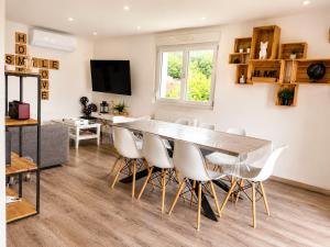 a dining room and living room with a table and chairs at Appart Vosges in Fresse-sur-Moselle