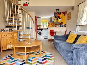 a living room with a blue couch and a table at Tramways Holiday Cottage in Carnbrea