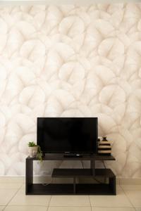 a living room with a tv and a wall at Iasonas Apartment 2 in Nafplio