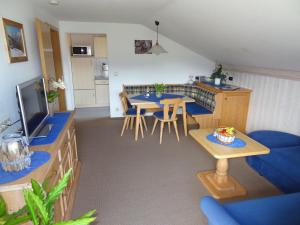 a kitchen and living room with blue tables and chairs at Gästehaus Koros in Fischen