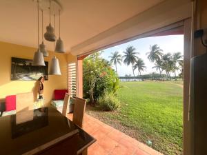 a kitchen with a view of a yard at Marisol les pieds dans l eau in Le Gosier