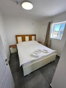 a bedroom with a bed with white sheets and a window at carmel cabins suite nu 10 in Haifa +21 photos