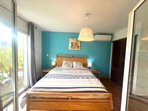 a bedroom with a bed with a blue wall at Marisol les pieds dans l eau in Le Gosier +20 photos