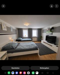 a bedroom with two beds and a television at Worker's Home by Nina in Herzberg am Harz