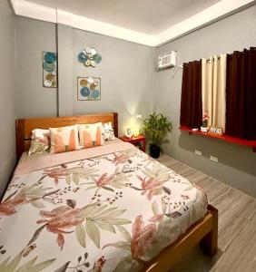 a bedroom with a bed with a floral bedspread at Shanti's Inn in General Luna