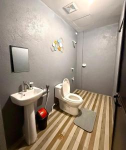 a small bathroom with a toilet and a sink at Shanti's Inn in General Luna