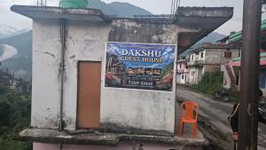 a sign on the side of a building at Dakshu guest house in Ukhimath