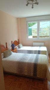 two beds in a bedroom with a window at Atalaya 5 - VUT5463AS in Ribadesella