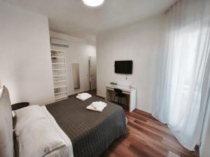 a bedroom with a bed and a desk and a television at Faber Home in Conversano