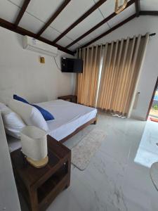 a bedroom with a bed and a table and a window at Beach 365 in Nilaveli