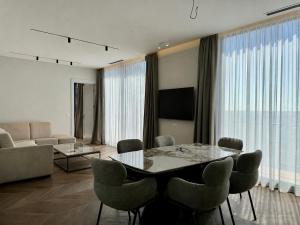 a living room with a table and chairs and a couch at Beachfront Luxury Villa - Bar in Bar