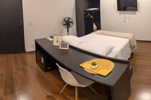 a bedroom with a desk with a bed and a chair at Nosso Hotel Extrema - recém inaugurado in Extrema