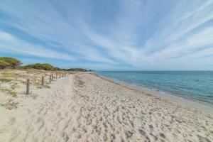 a sandy beach with a view of the ocean at Bilocale nuovo Budoni centro in Budoni
