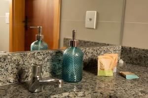 a bathroom sink with a bottle of soap and a mirror at Nosso Hotel Extrema - recém inaugurado in Extrema +33 photos