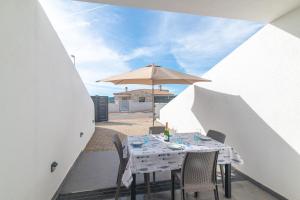 a table with an umbrella and chairs on a patio at Bilocale nuovo Budoni centro in Budoni