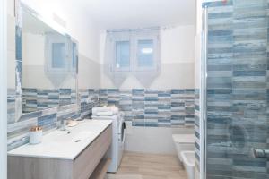 a bathroom with a sink and a toilet and a shower at Bilocale nuovo Budoni centro in Budoni +11 photos