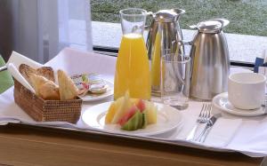 a tray with two plates of bread and juice and toast at NH Córdoba Urbano in Córdoba