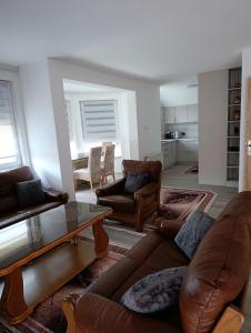 a living room with leather couches and a table at Apartman Lili in Bihać